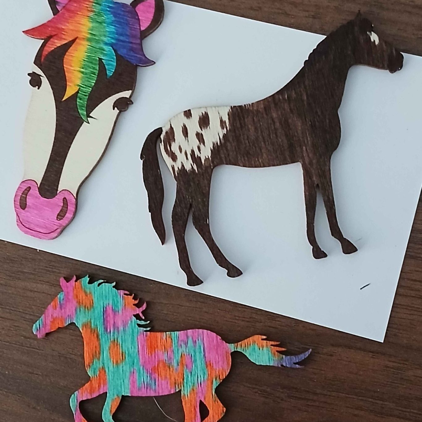 Colorful horse cutouts in various styles on a white background.