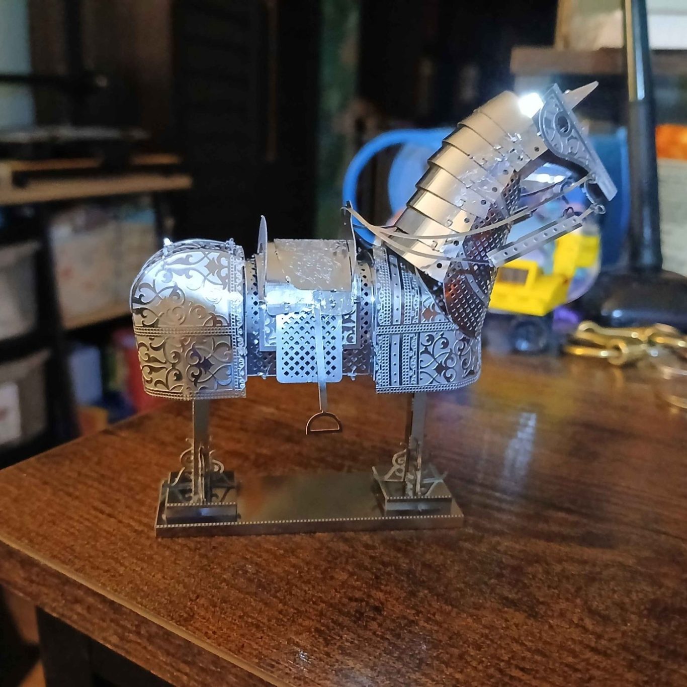 Metal model of horse armor, detailed with intricate patterns and a shiny finish.